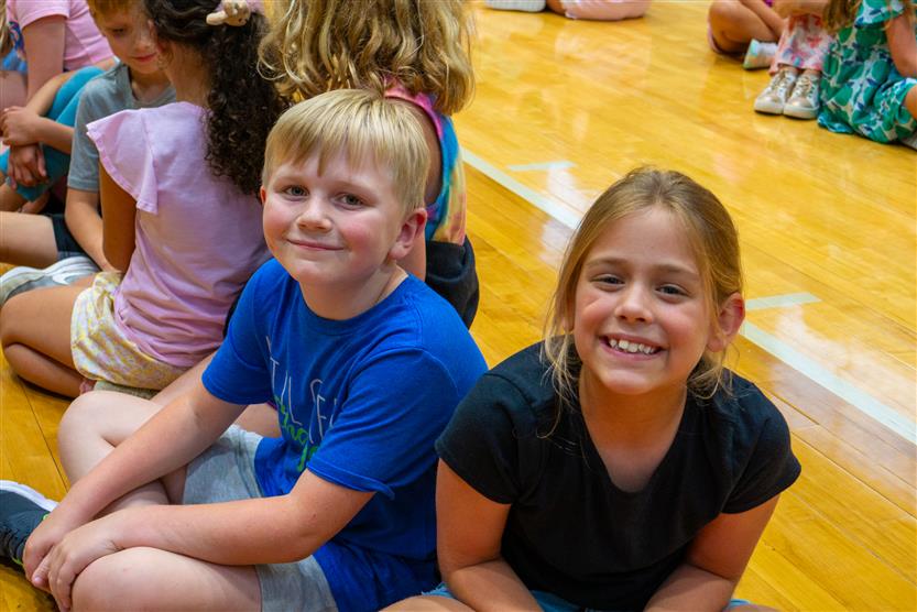 Students smile during an assembly